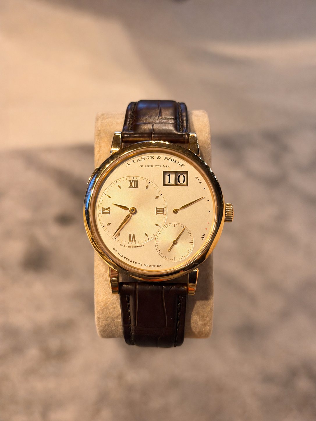A. Lange & Söhne Lange 1 in yellow gold resting on a watch cushion